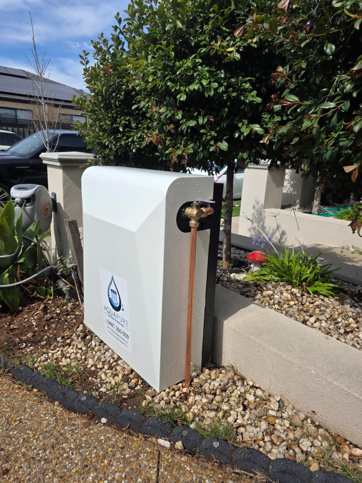 White enclosed system installed on the outside wall of a home